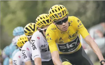  ?? CHRISTOPHE ENA — ASSOCIATED PRESS PHOTOGRAPH­S ?? Britain’s Chris Froome, wearing the overall leader’s yellow jersey, rides in the Tour de France on Friday.