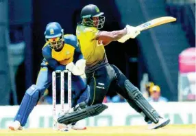  ?? RANDY BROOKS - CPL T20 ?? Rovman Powell of Jamaica Tallawahs hits a four as Andre Fletcher of St Lucia Zouks looks on during the Hero Caribbean Premier League T20 match at the Brian Lara Cricket Academy in Trinidad and Tobago yesterday.