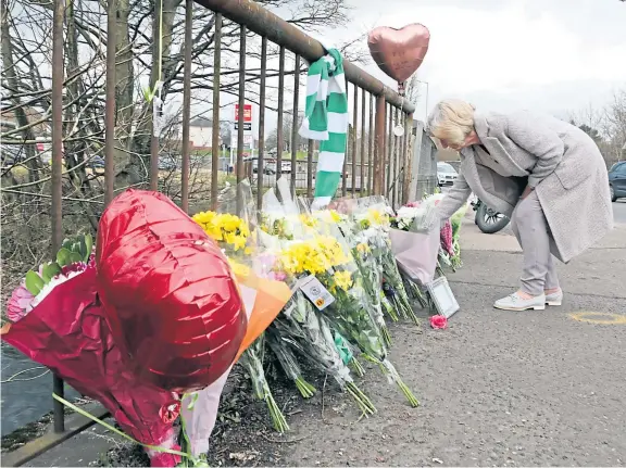  ?? Picture: Gareth Jennings. ?? A lady leaves flowers at a shrine to Cairn which has appeared near the scene of the tragedy on Pitkerro Road.