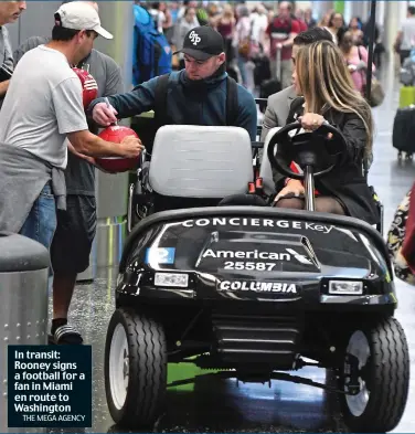  ?? THE MEGA AGENCY ?? In transit: Rooney signs a football for a fan in Miami en route to Washington