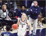  ?? David Butler II / Associated Press ?? UConn guard Paige Bueckers dribbles the ball as coach Geno Auriemma watches during the team’s game against St. John’s on Wednesday.