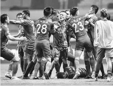  ??  ?? This file photo taken on June 18 shows a brawl erupting between Shanghai SIPG players (left) and Guangzhou R&F players (right) as Shanghai’s Oscar lies on the ground, during their Chinese Super League match in Guangzhou, in China’s southern Guangdong...