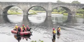  ??  ?? > Rescue crews in the River Wye at Builth Wells during the search for missing James Corfield, right