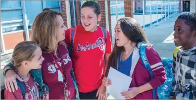  ?? WILLIAM HARVEY/THREE RIVERS EDITION ?? Mary Schmall, 11, left, hangs out with the new principal of Southwest Middle School, Carrie Parsley, and fellow students Tallin Todd, 11, Emma Glenn, 12, and Makairan Smith, 11, as they pass to another class. Parsley said it’s important that she models...