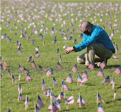  ?? WIN MCNAMEE/GETTY 2020 ?? Chris Duncan at a COVID Memorial Project installati­on on the National Mall in Washington. Duncan’s mother died from COVID-19 on her 75th birthday. More than 1 million people in the U.S. have died from COVID-19, according to the Johns Hopkins University.