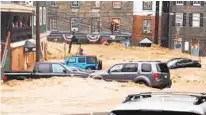  ?? LIBBY SOLOMON/BALTIMORE SUN MEDIA GROUP ?? Water rushes through Ellicott City’s historic Main Street. According to a National Weather Service meteorolog­ist, 7.48 inches of rain had fallen in Ellicott City by Sunday evening.