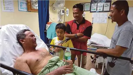  ?? PIC BY AMRULLAH ABDUL KARIM ?? Mohamad Rosely Azli looking upbeat with his youngest son Mu’az Bunyameen ‘Aqil, 9, while receiving treatment at Kuala Kubu Baru hospital yesterday.