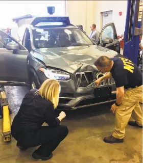  ?? National Transporta­tion Safety Board ?? Investigat­ors with the National Transporta­tion Safety Board examine the Uber autonomous SUV that fatally struck a woman in Tempe, Ariz.