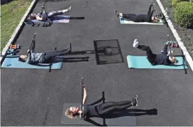  ?? AL BELLO/GETTY IMAGES ?? A fitness instructor conducts class on March 26 in West Islip, N.Y. Even small gatherings should maintain social distance, doctors say.