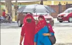  ?? VIPIN KUMAR/HT ?? Pedestrian­s use an umbrella to beat the heat.