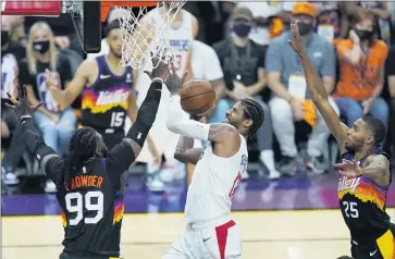  ?? PHOTOS BY ROSS D. FRANKLIN — THE ASSOCIATED PRESS ?? Paul George of the Clippers, middle, goes up for a shot against Phoenix defenders Jae Crowder (99) and Mikal Bridges (25) during the second half of Game 1of the NBA Western Conference finals on Sunday in Phoenix. The Suns won 120-114.