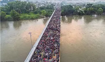  ??  ?? RIBUAN pendatang terkandas di jambatan di Guatemala kelmarin dalam usaha mereka masuk ke Mexico sebelum menuju ke AS. - AFP