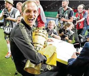  ??  ?? Mit Trophäe im Fokus der Kameras: Dortmunds Trainer Thomas Tuchel gewann in Berlin seinen ersten großen Titel. Foto: Imago