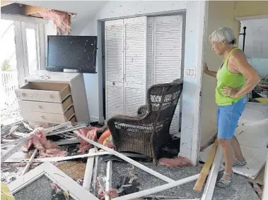  ?? TAIMY ALVAREZ/STAFF FILE PHOTO ?? Donna Thompson looks into a bedroom of her stilt home in Jolly Roger Estates after Hurricane Irma struck Little Torch Key.