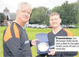  ??  ?? Presentati­on Gus McGregor (left) hands over a plate to Douglas Smith, uncle of Liam, to mark day