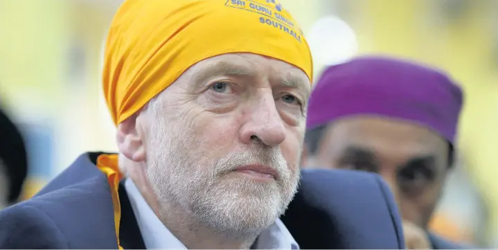 ??  ?? > Labour leader Jeremy Corbyn joins worshipper­s at the Sri Guru Singh Sabha in Southall, London, during a general election campaign visit yesterday
