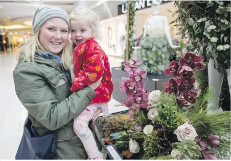  ??  ?? Kim Spears and three-year-old daughter Marina Spears check out the Fleurs de Villes floral mannequin series at Mayfair Shopping Centre.