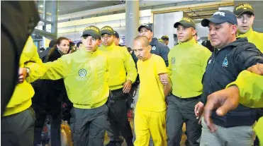  ?? FOTO JOHNNY HOYOS ?? Juan Carlos Sánchez Latorre es custodiado por un grupo de uniformado­s en el aeropuerto El Dorado.