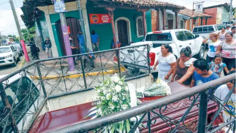  ??  ?? El cortejo fúnebre de Erick Jiménez López, de 15 años, pasa frente a milicianos armados del gobierno en el barrio Monimbó de Masaya, Nicaragua.
