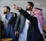  ?? TASNEEM ALSULTAN / THE NEW YORK TIMES ?? Customers at a coffee shop Tuesday in Riyadh, Saudi Arabia, look at a cloud of smoke that followed a loud boom. The Saudi government said it had intercepte­d a Houthi missile.