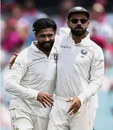  ??  ?? Well done: India’s Ravindra Jadeja (left) is congratula­ted by his captain Virat Kohli after taking the wicket of Australia’s Shaun Marsh for eight runs on the third day of their cricket Test match in Sydney yesterday.