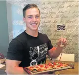  ?? Picture: GILLIAN McAINSH ?? YUMMY AND HEALTHY: Eduan Meyer serves a cauliflowe­r-based pizza at Vovo Telo this week at the coffee shop's menu revamp