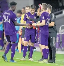  ?? STEPHEN M. DOWELL/ORLANDO SENTINEL ?? Coach Oscar Pareja and players talk during a preseason game. He emphasizes competitio­n and gives every player a chance to earn a starting spot.