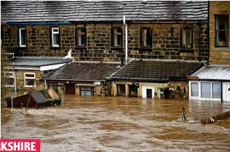  ??  ?? Bridge in the Pennines is left under water as the floods rise against the windows of houses in Mytholmroy­d yesterday