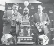  ?? STEPHEN M. DOWELL/ORLANDO SENTINEL ?? LSU coach Ed Orgeron, left, and UCF coach Josh Heupel prepare for a photo with the Fiesta Bowl trophy.