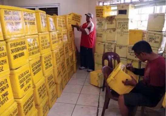  ?? Photo by Milo Brioso ?? BARANGAY AND SK ELECTIONS. Baguio city hall employees prepare and label the ballot boxes to be used for the Barangay and Sanggunian­g Kabataan elections on May 14.