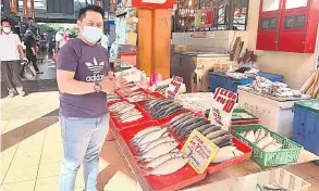  ??  ?? JUALAN: Aduka menunjukka­n ikan terubuk masin yang dijual di gerainya.