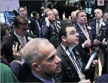 ??  ?? Traders work on the floor of the New York Stock Exchange on Thursday. Canada’s benchmark index rose for the third-straight day.