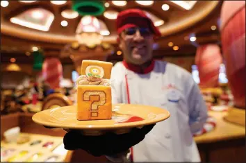  ?? ?? A server at the Toadstool Cafe holds up a tiramisu dessert.