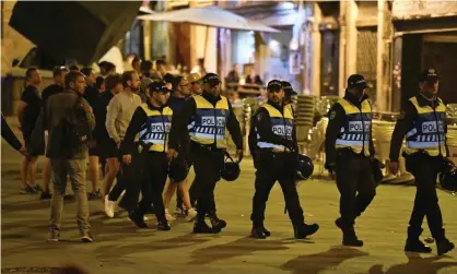  ?? Photograph: Martin Meissner/AP ?? Police officers monitor English supporters who were drinking and singing in Porto the day after England lost their Uefa Nations League semi-final against the Netherland­s.