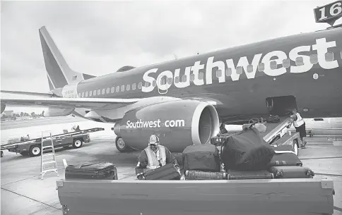  ??  ?? A ground operations employee loads baggage onto a Southwest Airlines Boeing 737 on the tarmac at John Wayne Airport (SNA) in Santa Ana, California, on April 14. — WP-Bloomberg photo