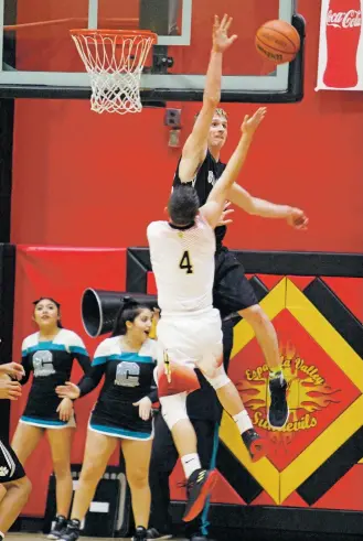  ?? LUIS SÁNCHEZ SATURNO/THE NEW MEXICAN ?? Capital’s Matt Smith, back, blocks a shot from Española Valley’s Isaiah Vigil during Tuesday’s game at Española.