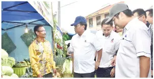  ??  ?? (gambar kiri) SHAFIE berkata sesuatu kepada salah seorang pengusaha kebun sayur di Kundasang yang mengambil bahagian dalam pameran hasil-hasil pertanian sayur-sayuran.