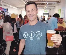  ?? STEVE MACNAULL ?? Sac Brew Bike owner Chris Ferren with a glass of Man Bun Pale Ale from Yolo Brewing in West Sacramento.