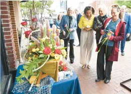  ?? BRIAN KRISTA/CAPITAL GAZETTE ?? City of Annapolis First Lady Julie Williams Buckley, First Lady of Maryland Dawn Moore, Joanne Buck, wife of Vice Admiral Sean Buck, U.S. Naval Academy Superinten­dent and First Lady of Anne Arundel County Erin Pittman admire a nautical-themed flower display in front of a business on Main Street during a tour of the 68th annual May basket competitio­n, sponsored by the Garden Club of Old Annapolis Towne on May 1.