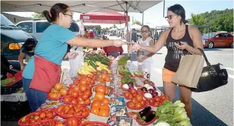  ??  ?? Jessica Diaz (right) and daughter Vianny Diaz, 10, of Bella Vista buy produce from Kalia Yang of Lincoln, during the Bella Vista Farmers Market in the parking lot of Mercy Bella Vista. NWA Democrat-Gazette/BEN GOFF @NWABENGOFF