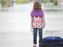  ?? STUART GRADON ?? A child looks out at flood water in High River June 20, 2013. Many in the area were displaced.