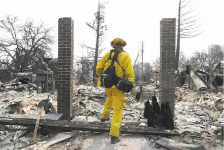  ?? Jim Wilson / New York Times ?? Firefighte­r Adam Wilson steps over the threshold of a destroyed home in a neighborho­od burned by the Carr Fire in Redding.