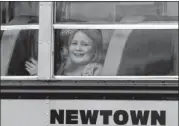  ??  ?? A student waves as her bus pulls into Hawley School Tuesday in Newtown, Conn. Classes resumed at all public schools except for Sandy Hook Elementary.