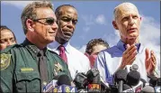  ?? LANNIS WATERS / THE PALM BEACH POST ?? Broward County Sheriff Scott Israel (from left) and Broward County Schools Superinten­dent Robert W. Runcie listen as Florida Gov. Rick Scott speaks Thursday outside the high school.