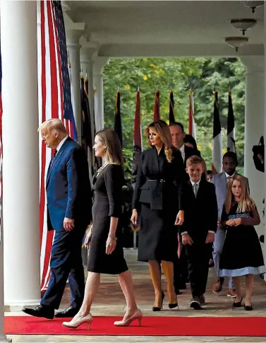  ??  ?? SHIFTING THE BALANCE
President Trump and Melania Trump with Judge Amy Coney Barrett and her family entering the Rose Garden at the White House on September 20.