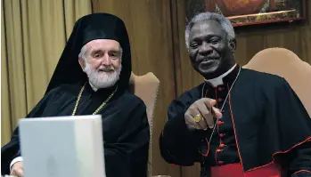  ?? VINCENZO PINTO/AFP/GETTY IMAGES ?? Orthodox metropolit­an of Pergamon Joannis Zizioulas and Cardinal Peter Kodwo Appiah Turkson look at copies of Pope Francis’ encyclical on climate change, which has the whole world buzzing.