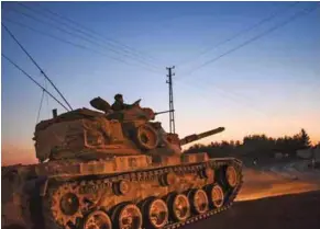  ?? – AFP ?? CONFLICT CONTINUES: A Turkish army tank is pictured driving back to Turkey from the SyrianTurk­ish border town of Jarabulus on Thursday in the Turkish-Syrian border town of Karkamis.