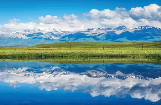  ??  ?? Le reflet des monts Tianshan dans l’eau, le long de l’autoroute de Duku, dans la préfecture autonome mongole de Bayingol