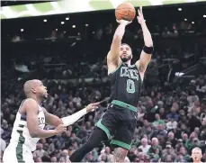  ?? ?? Jayson Tatum, de los Celtics, lanza el balón frente a Khris Middleton, de los Bucks, en el encuentro de la NBA.