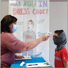  ?? (AP/LM Otero) ?? Science teacher Ann Darby checks sixth grader Anthony Gonzales’ temperatur­e Tuesday before letting him enter a summer science and technology camp at Wylie High School in Wylie, Texas.